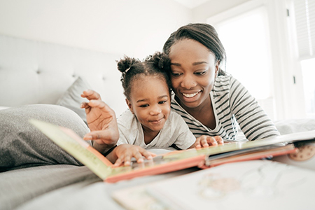 Parent reading a book to her child